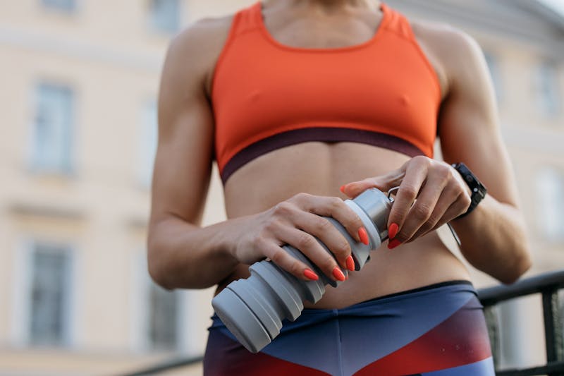 Active woman holding a tumbler — hydration, energy, and wellness on the go