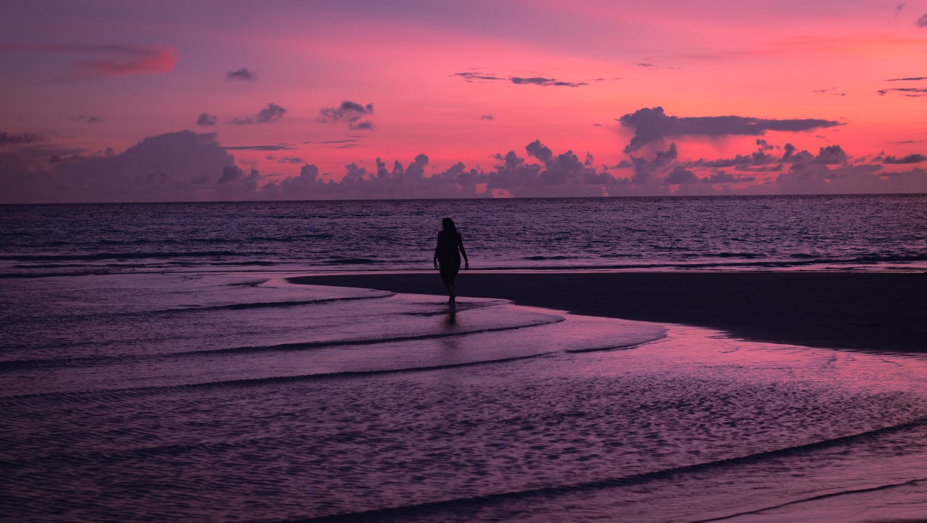 A Gulf shoreline at vivid pink-magenta sunset