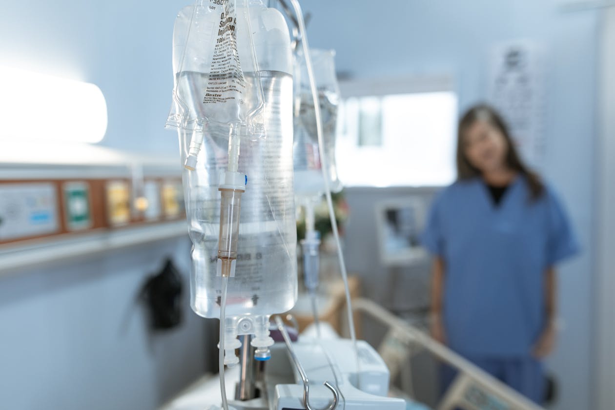 Close-up IV drip bag in clinic — professional nurse-led IV hydration